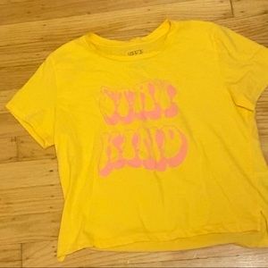 yellow crop top with letter in pink saying “be kind”